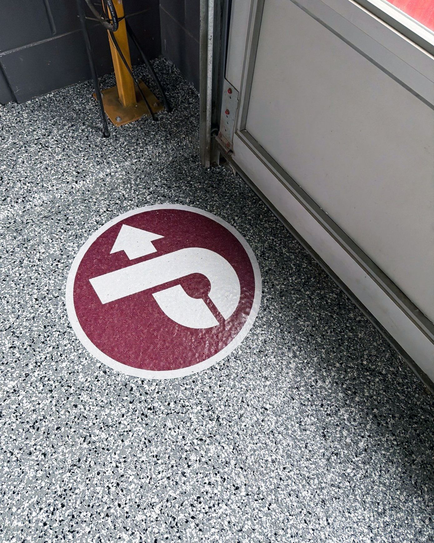 Full-flake epoxy floor with inset logo graphic in automobile service bay