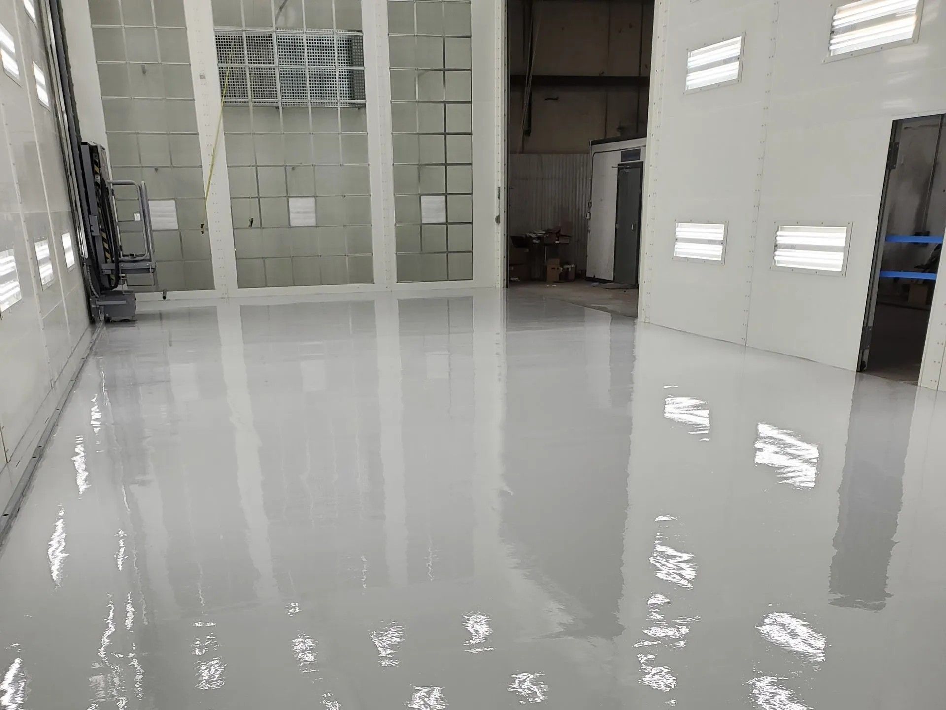 Commercial paint booth interior with solid-color epoxy floor