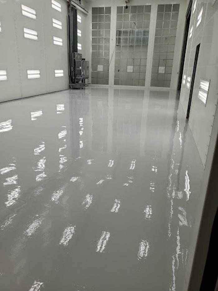 Commercial paint booth interior with solid-color epoxy floor