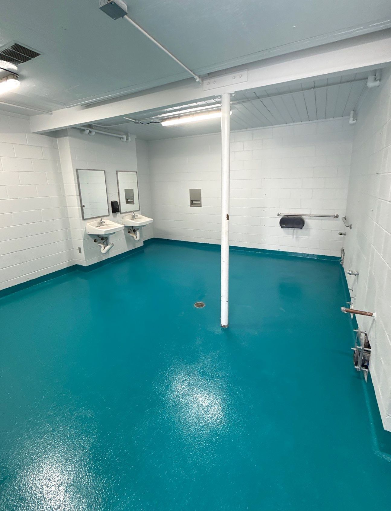 Solid-color epoxy floor in city pool interior rooms with full broadcast of 16/30 mesh sand for traction