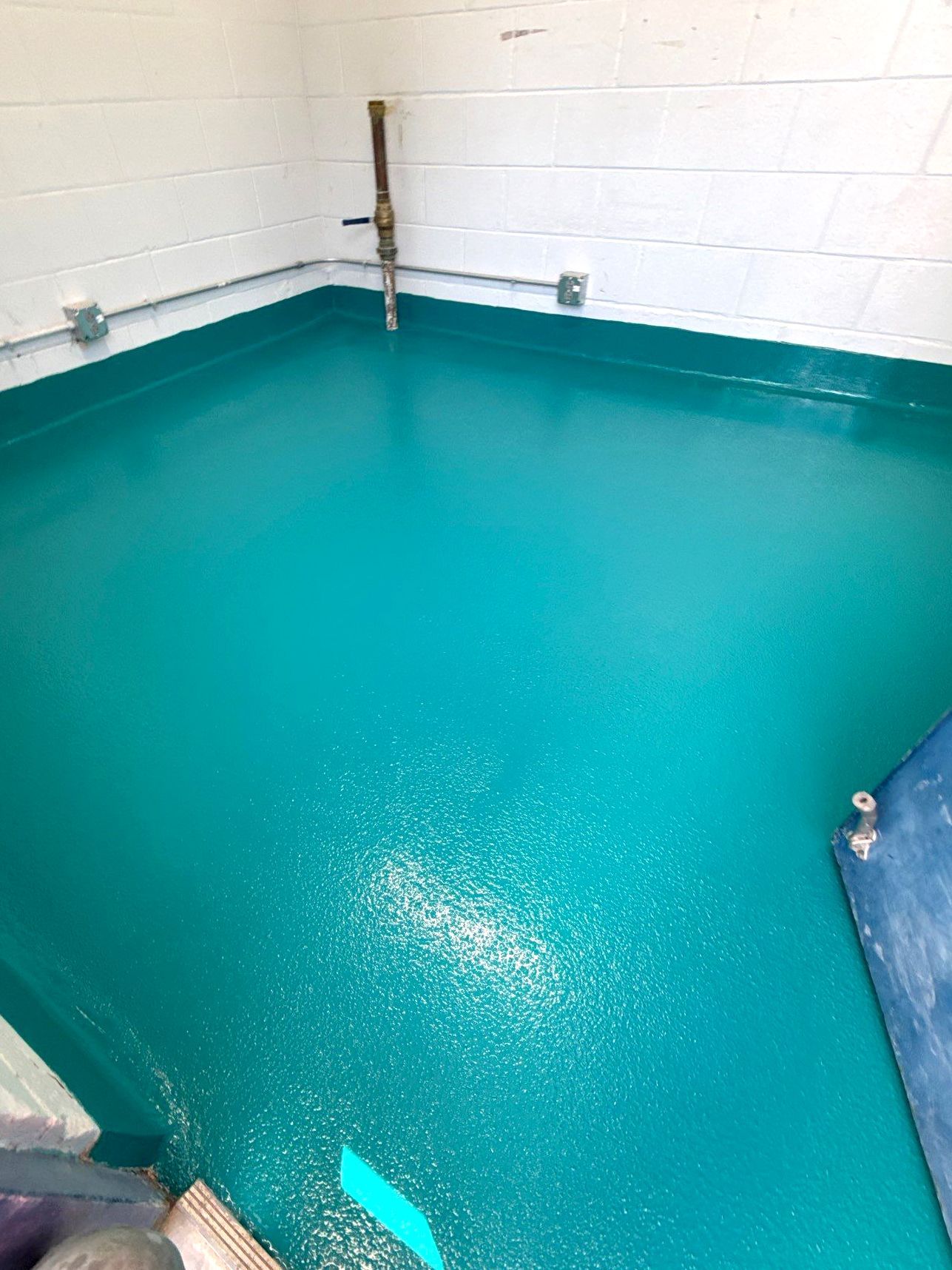 Solid-color epoxy floor in city pool interior rooms with full broadcast of 16/30 mesh sand for traction