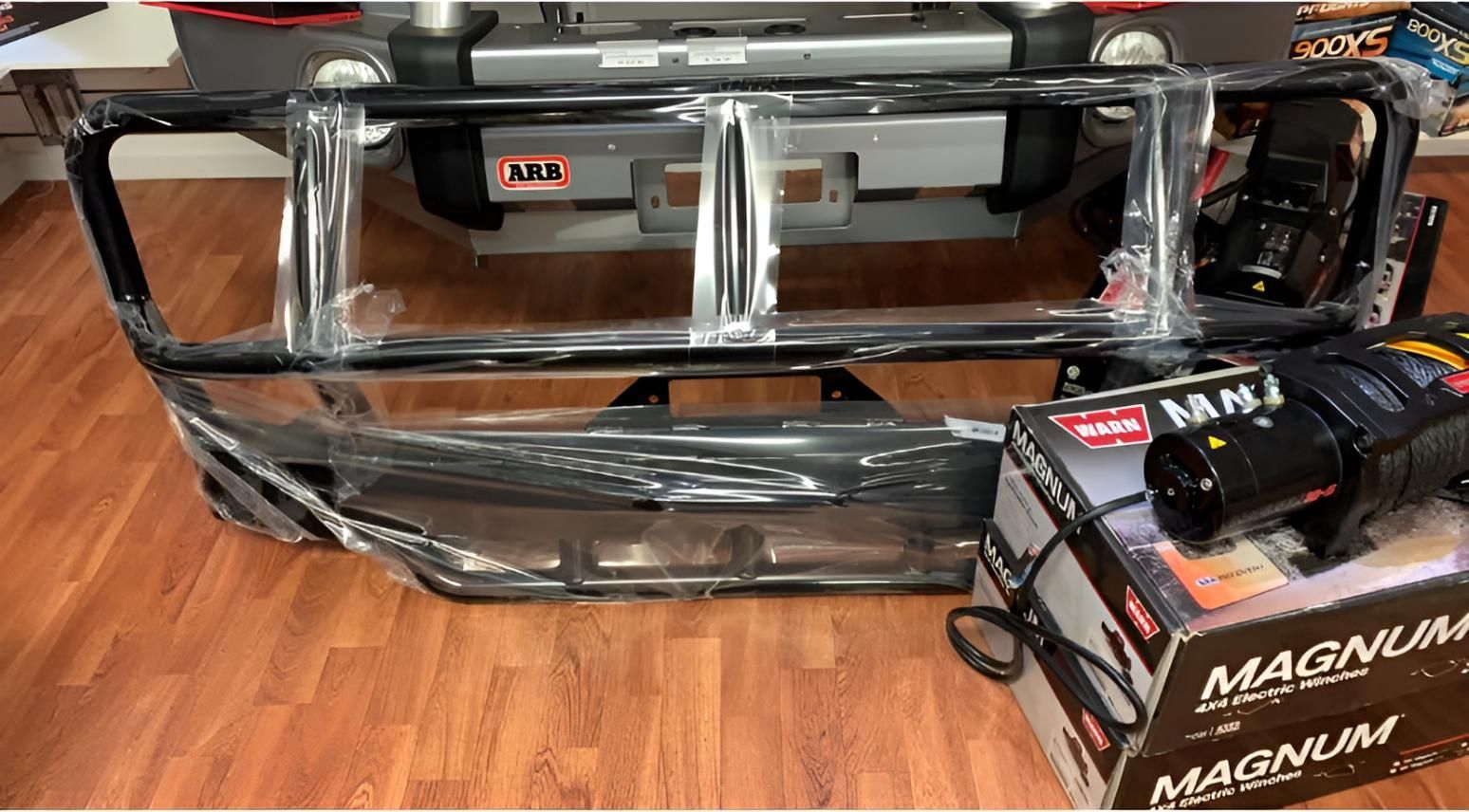 A Front Bumper With A Winch Attached To It Is Sitting On A Wooden Floor — Tech Tune Automotive and 4x4 ARB In Innisfail, QLD