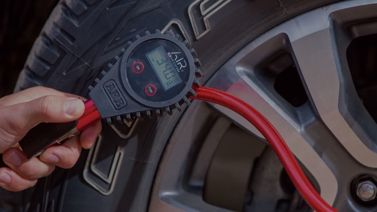 A Person Is Checking The Pressure Of A Tire With A Digital Tire Gauge — Tech Tune Automotive and 4x4 ARB In Innisfail, QLD