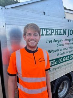 A man standing in front of a stephens tree supply truck