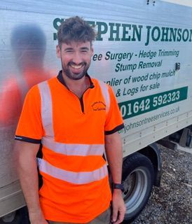 A man in a green shirt is standing in front of a stephen john truck
