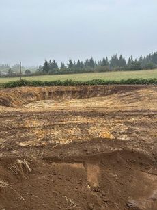 A large pile of dirt is sitting in the middle of a field.