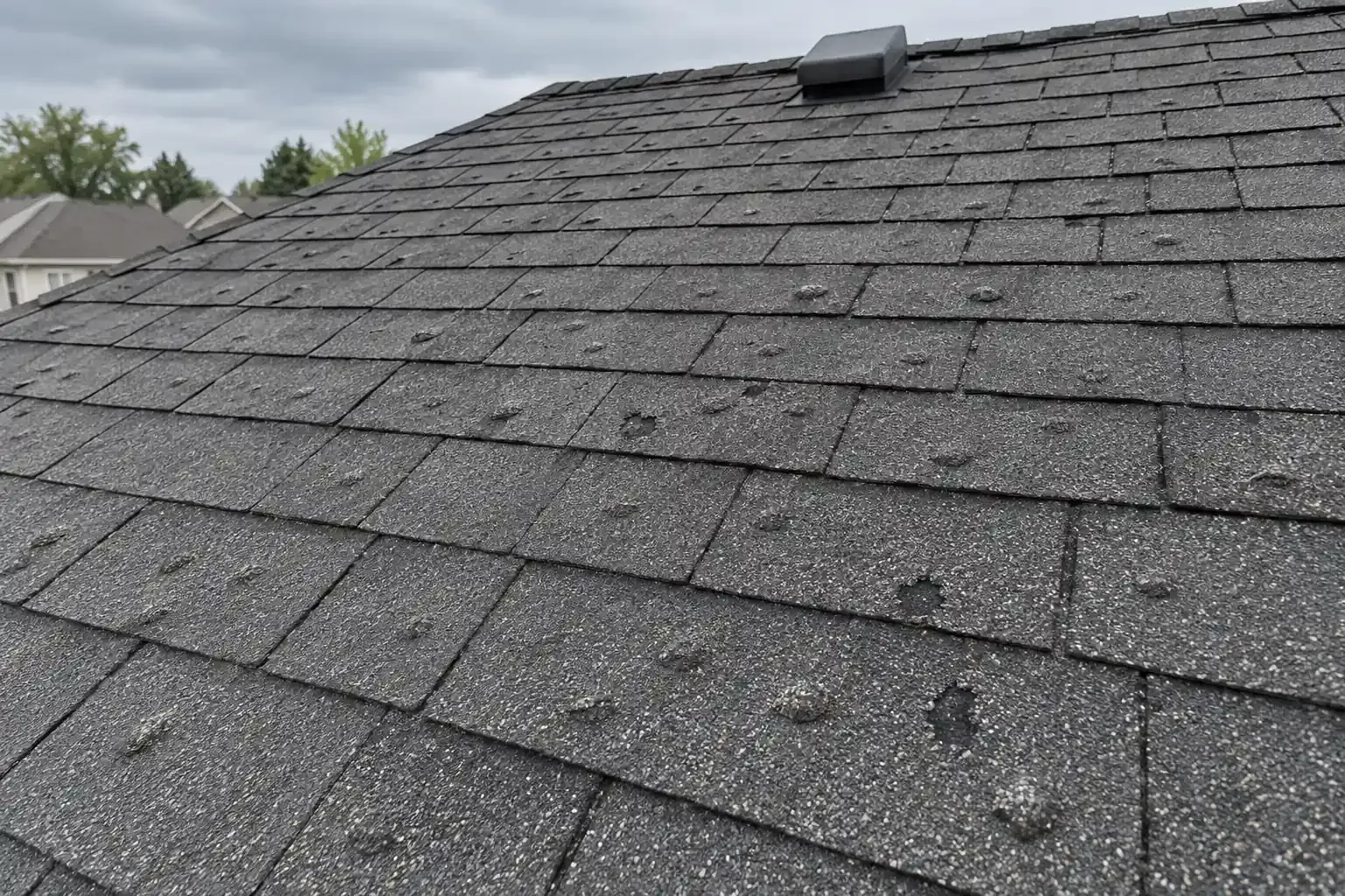 Blistered asphalt shingles on a roof with too few vents