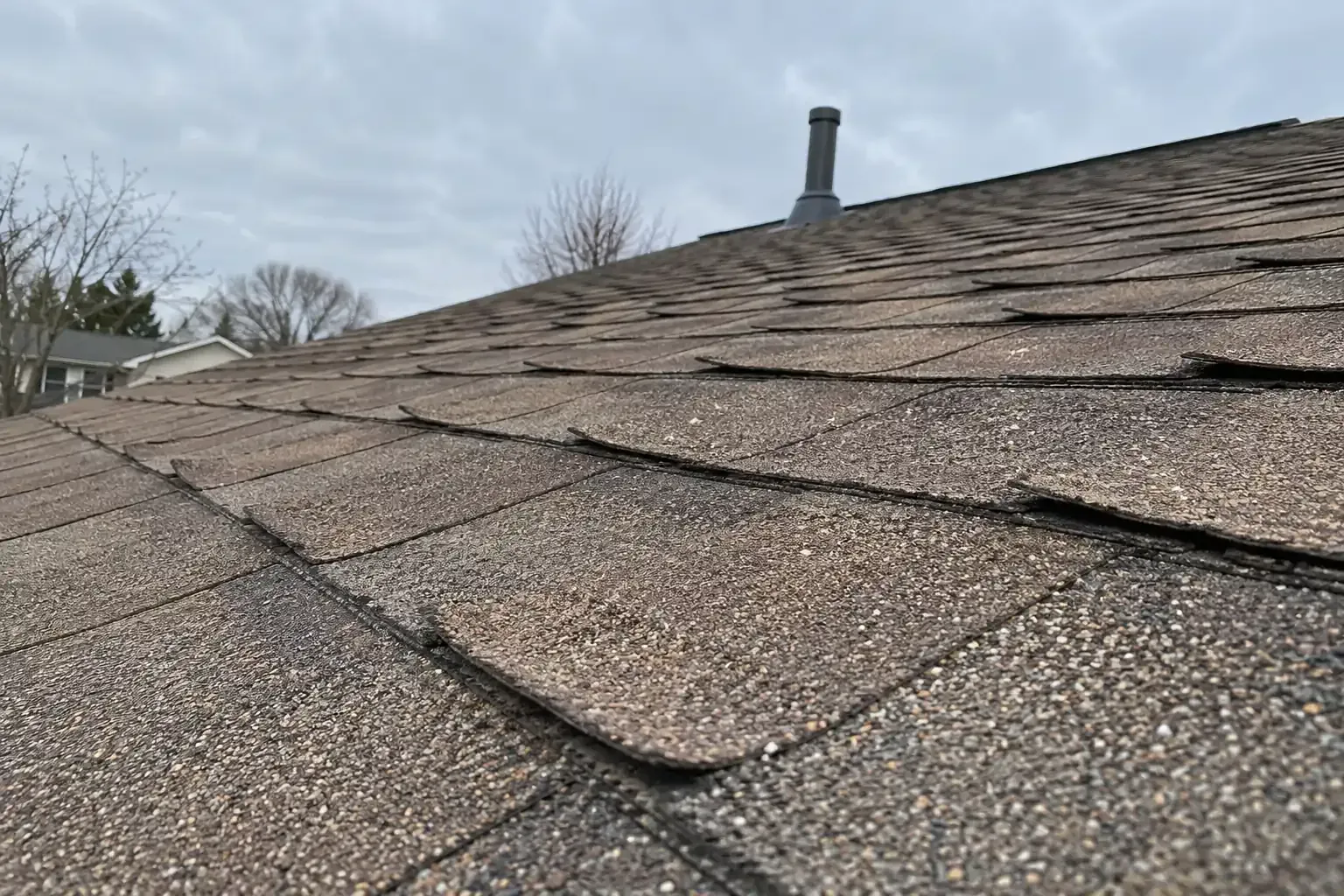 Curling corners on a row of older asphalt shingles