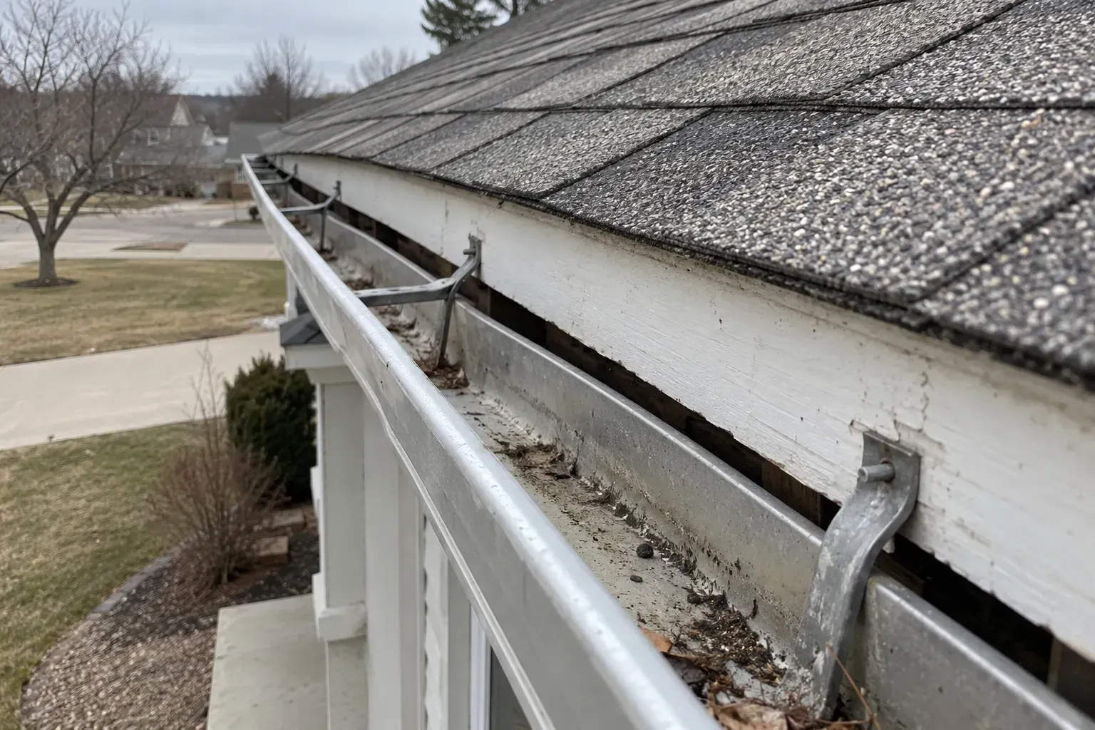 Gutter torn loose from its hangers along a roof edge