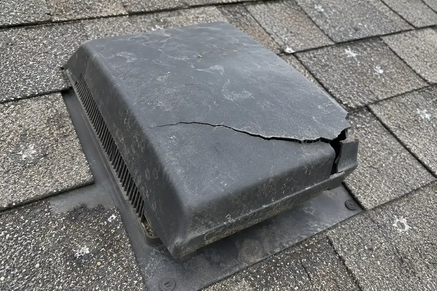 Faded plastic roof vent with a crack across its top