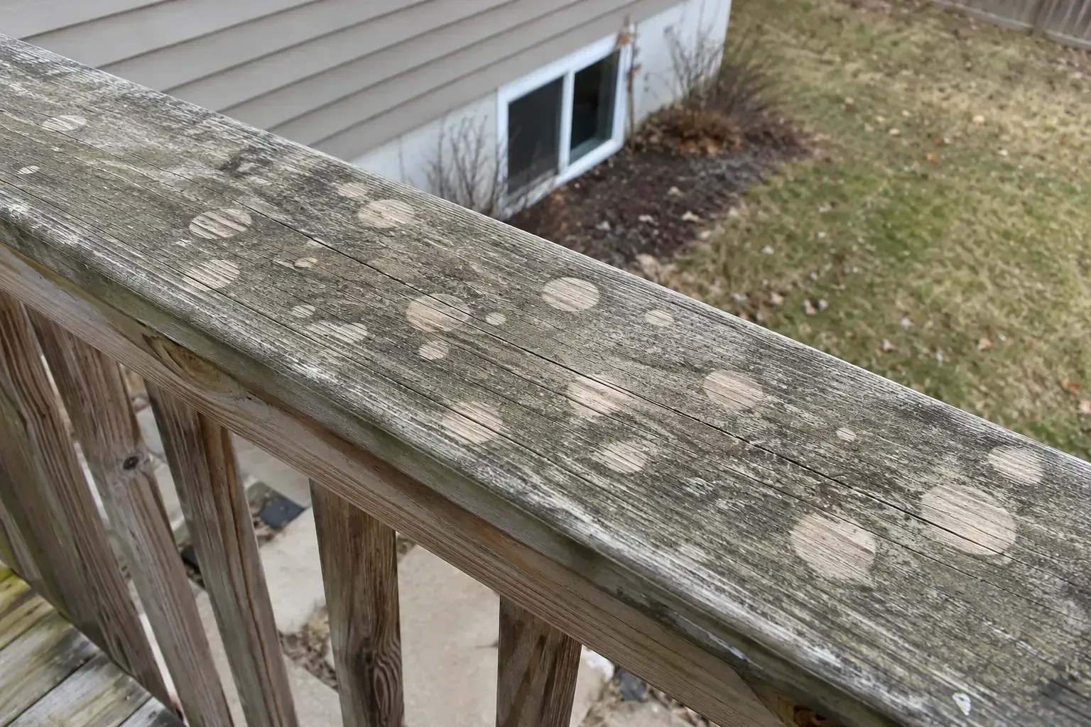Fresh hail spatter on a dusty grill cover and deck boards