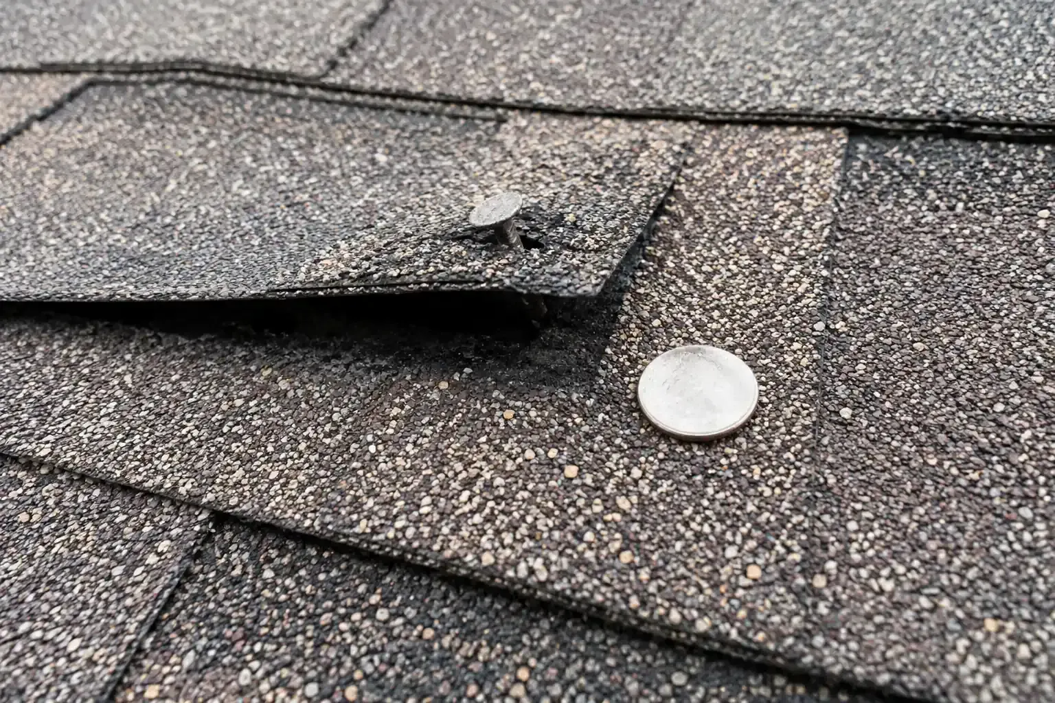 Nail head raised under a shingle, marked with a chalk circle
