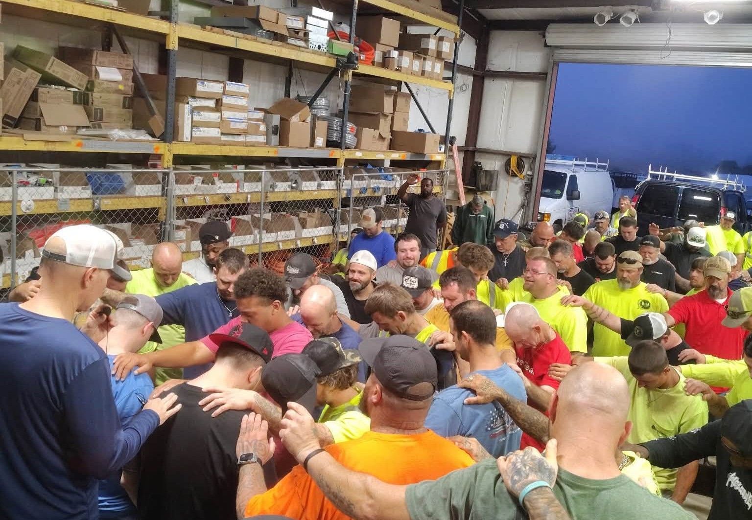 Abel crew gathered for morning devotion and prayer in the warehouse in Salem, AL