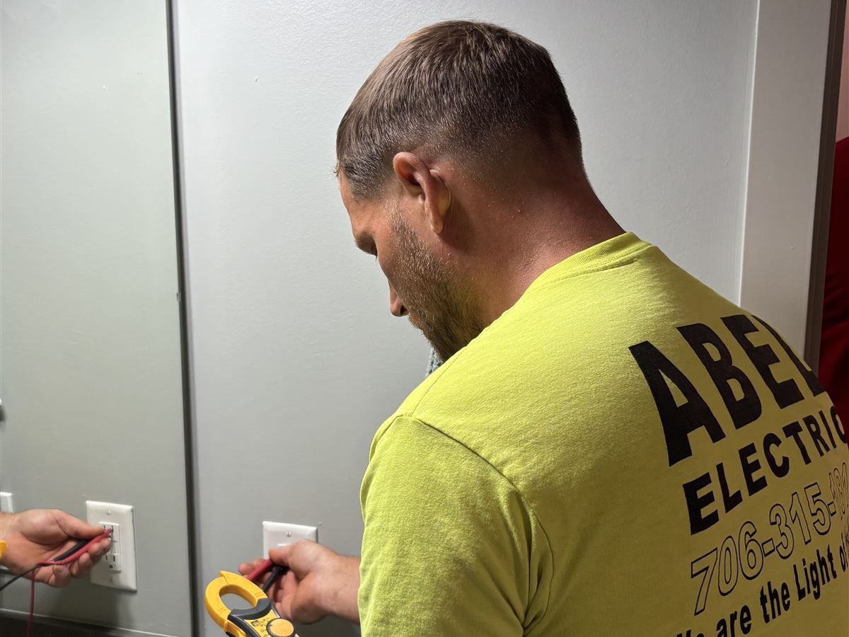 Abel Electric electrician troubleshooting an outlet at an Auburn AL apartment