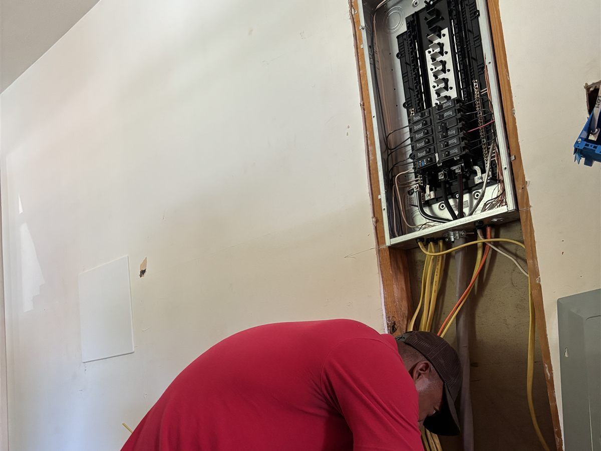 Electricista de Abel Electric trabajando en un panel eléctrico dentro de una casa