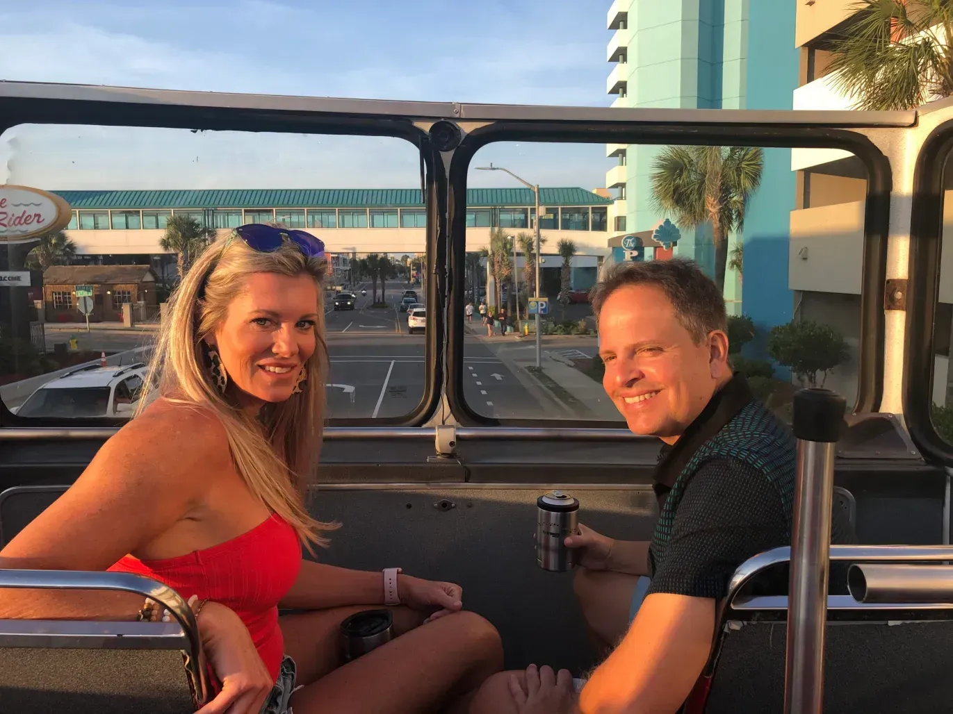 A man and a woman are sitting on the back of a bus.