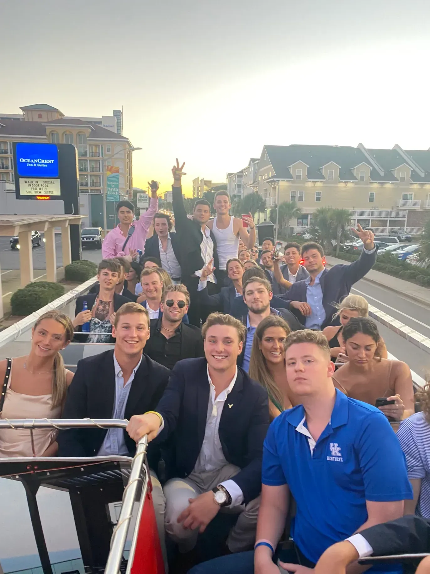 A group of people are sitting on top of a double decker bus.