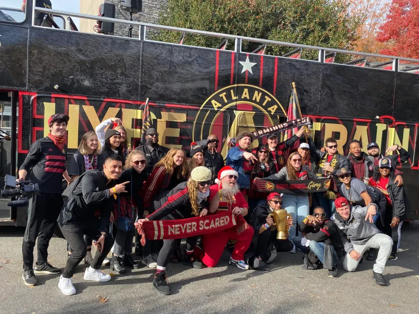 A group of people are posing for a picture in front of a bus.