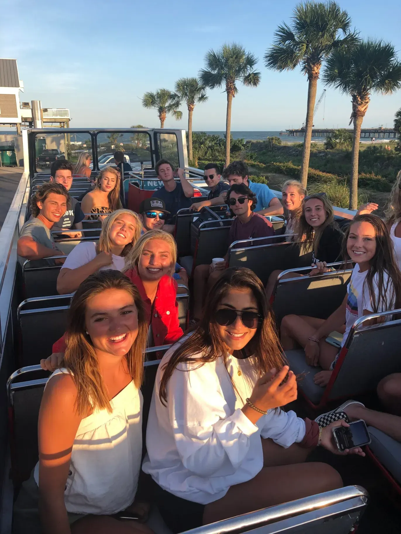 A group of people are sitting on top of a double decker bus.