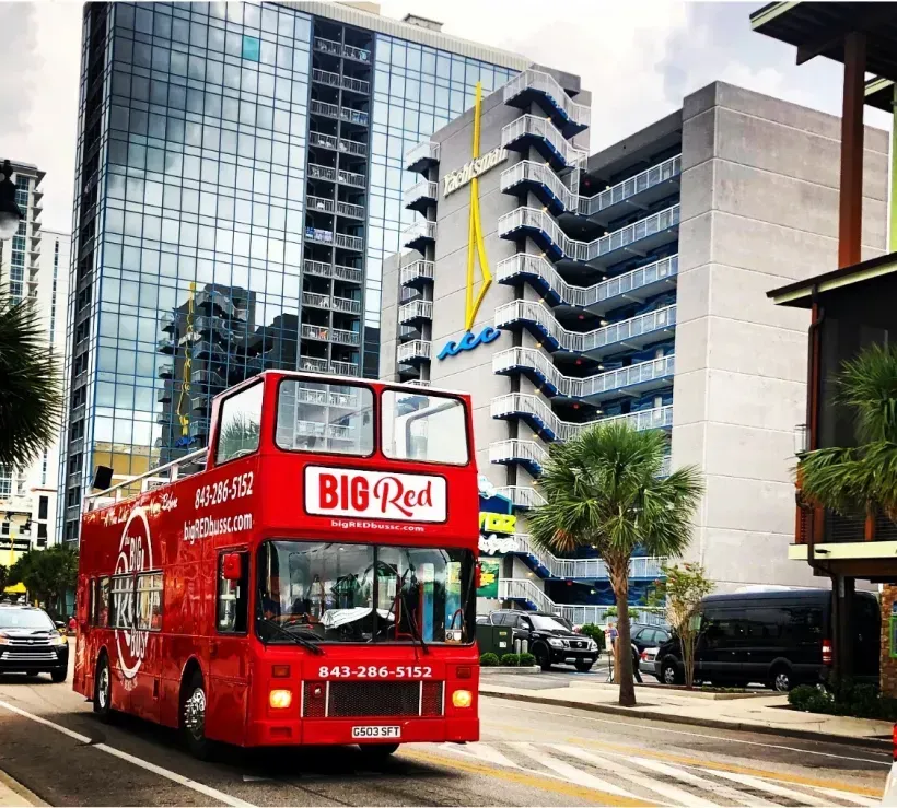 A big red bus is driving down a city street