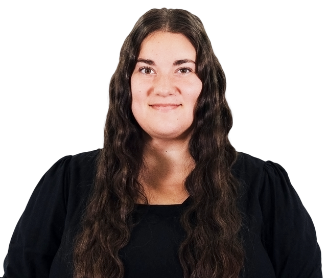 Portrait of a smiling woman with long dark wavy hair wearing a black top on a white background