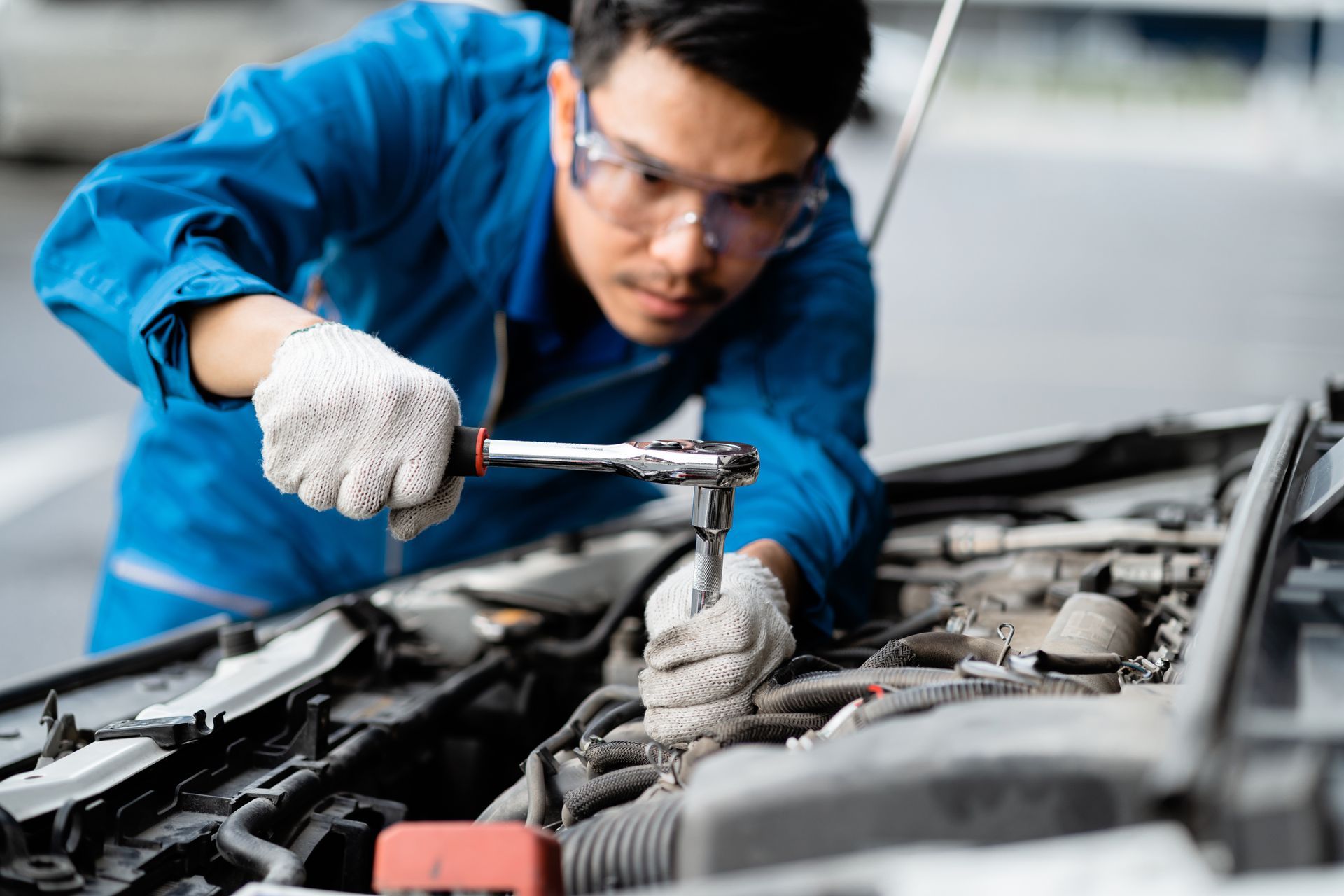 Close-up of an auto mechanic repairing a car in a garage, for safety check.