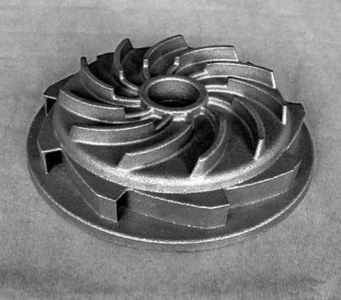 Girante metallica per pompa centrifuga con pale curve su una base circolare piatta.