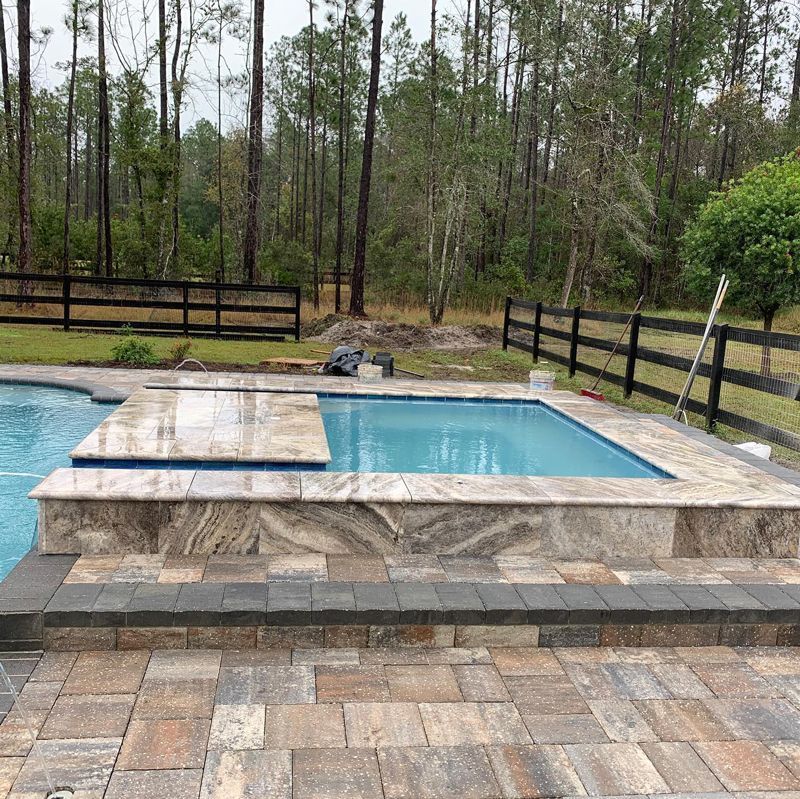 A large swimming pool with a fence in the background
