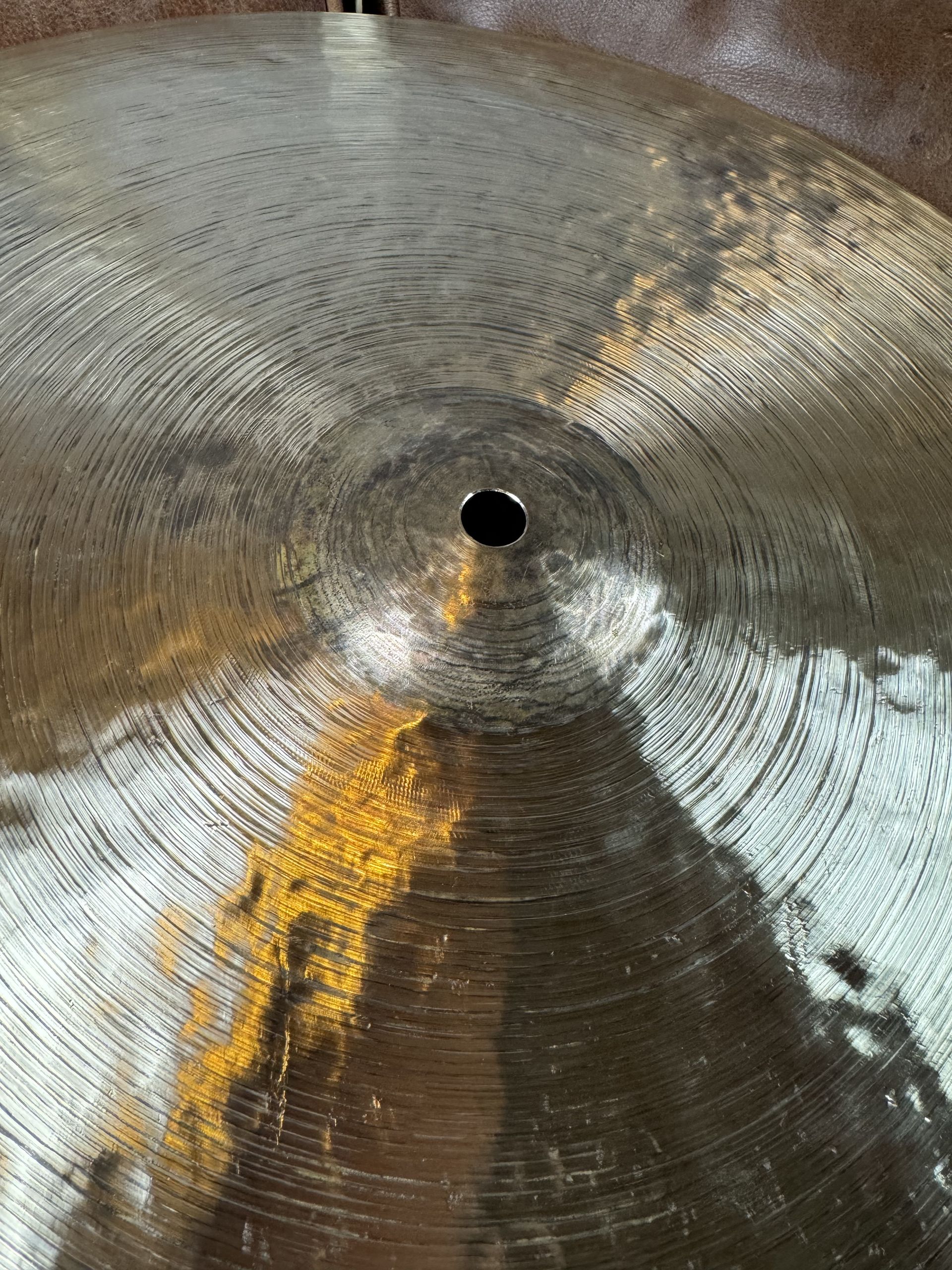 Close-up of a metal fan or propeller with a central black hole and silver-gold blades attached