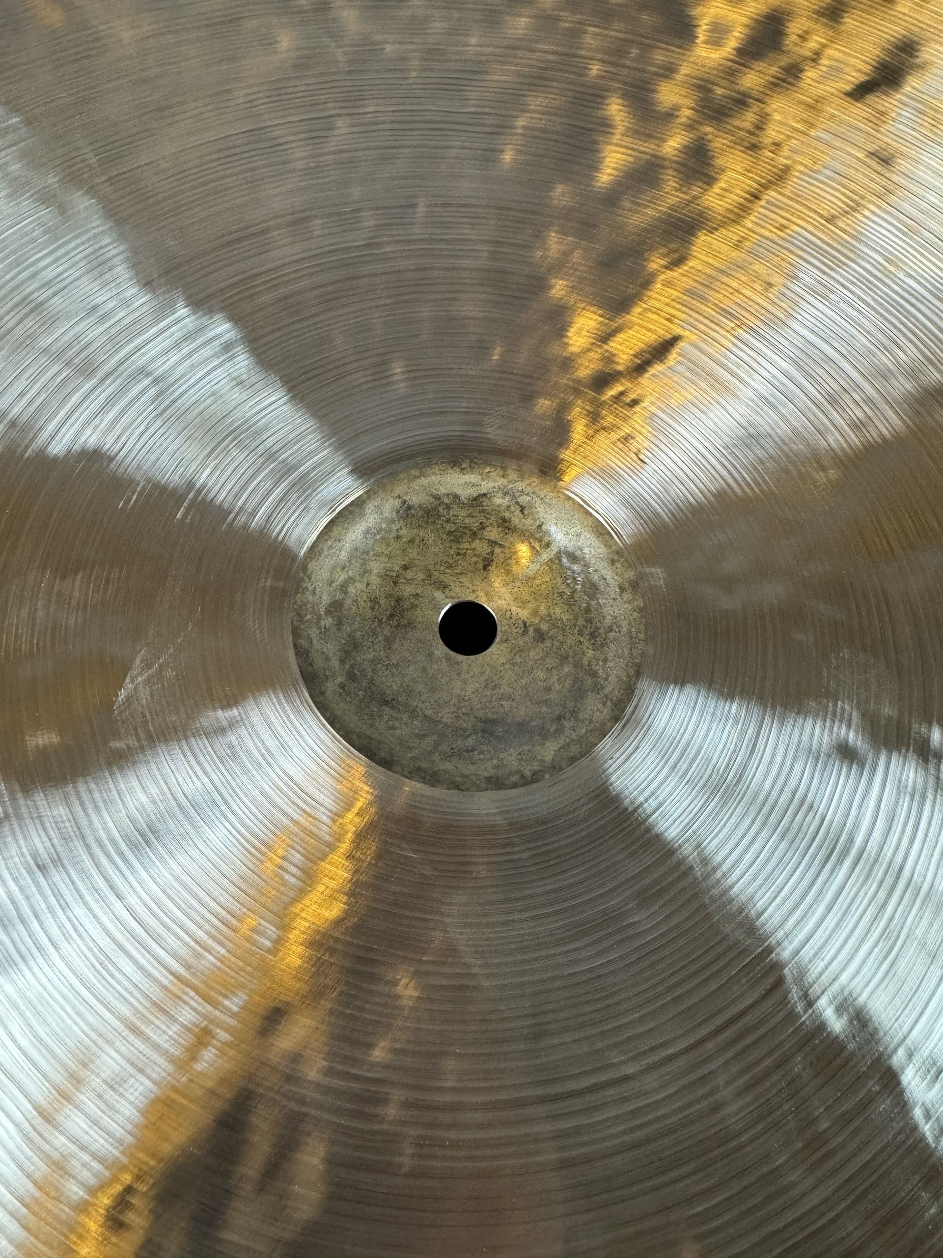Close-up of a metal fan or propeller with a central black hole and silver-gold blades attached