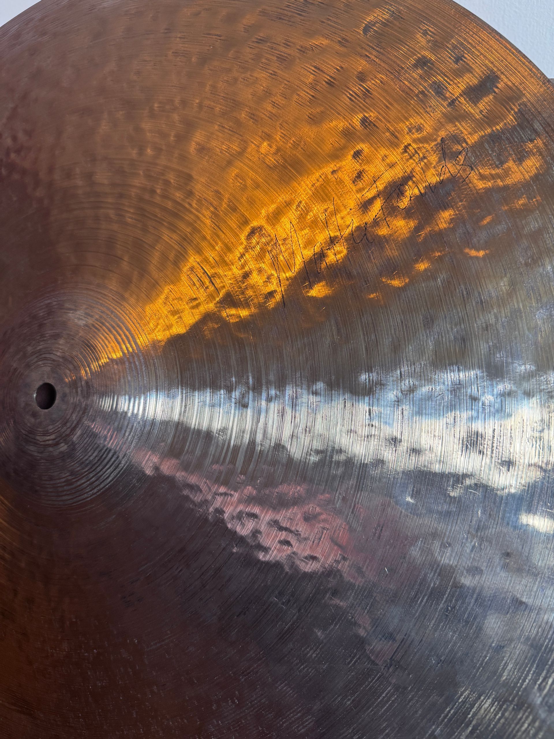 Close-up of a metallic surface with a bright orange and silver light reflection