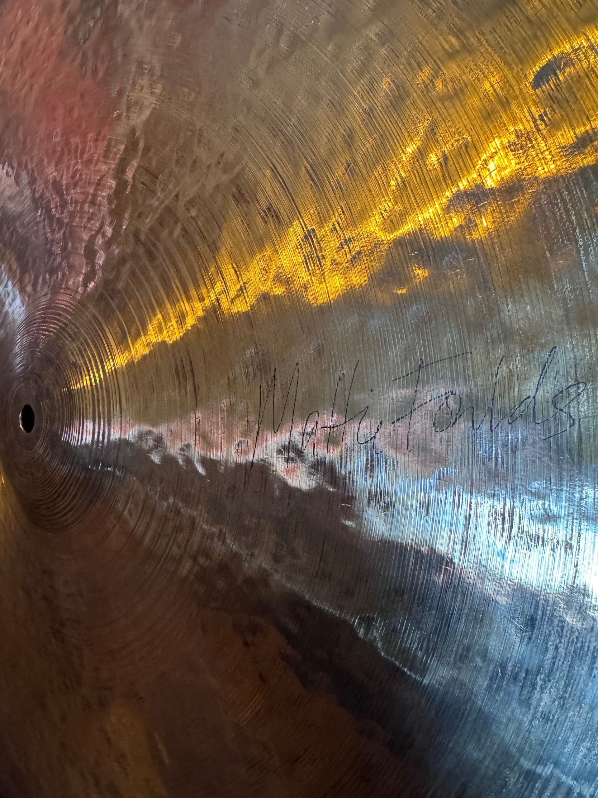 Abstract metallic surface with streaks of gold, silver, and brown light reflections