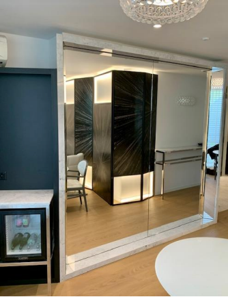 Cloison de séparation en miroir reflétant un intérieur moderne avec des accents art déco et un petit coin bar.