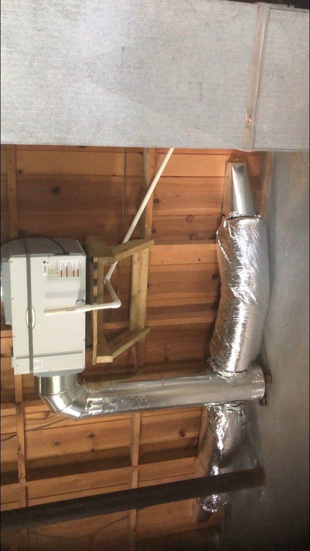 A gas meter and flexible ductwork are installed on a wooden ceiling.
