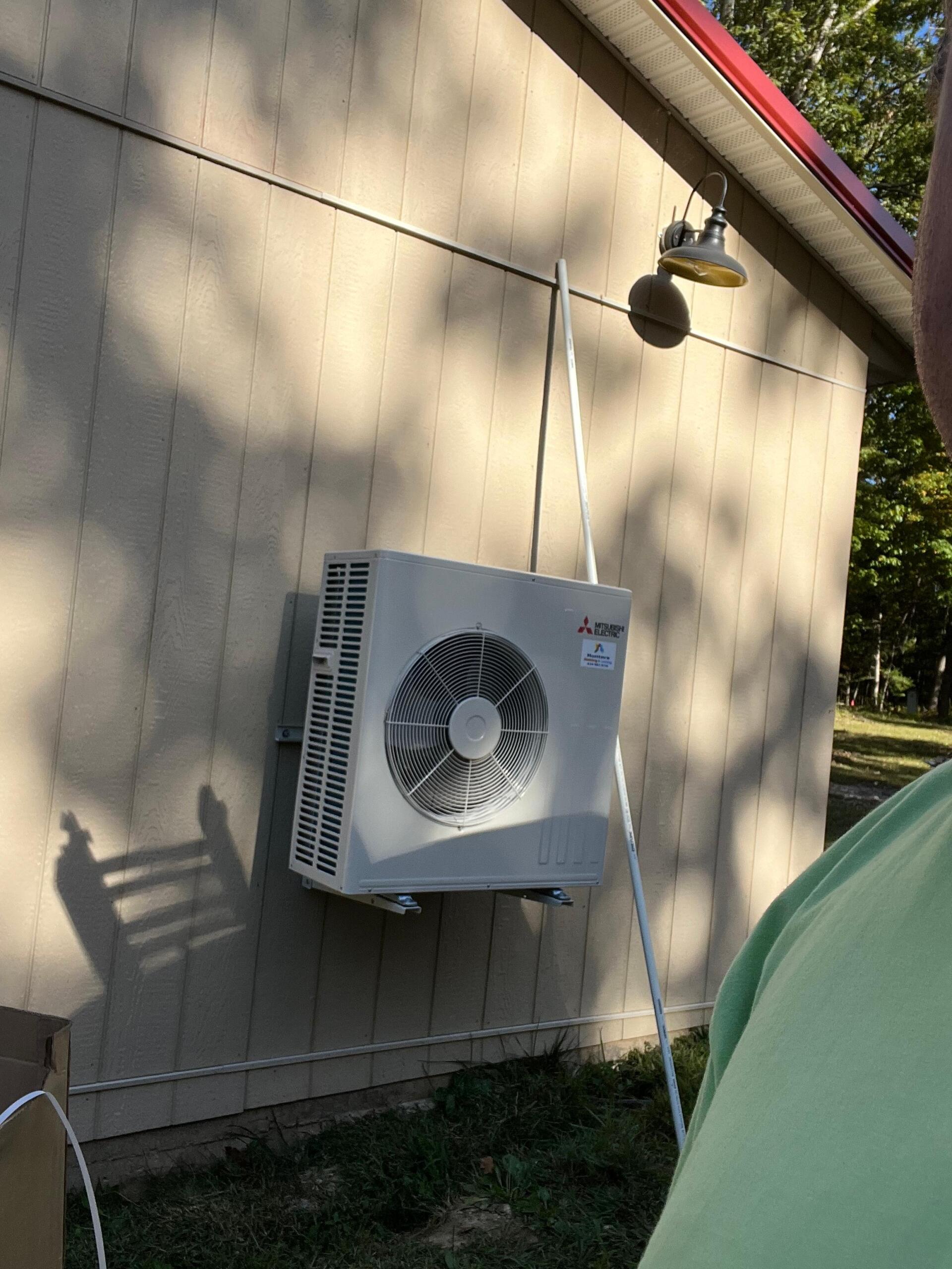 Exterior HVAC unit mounted on building wall.