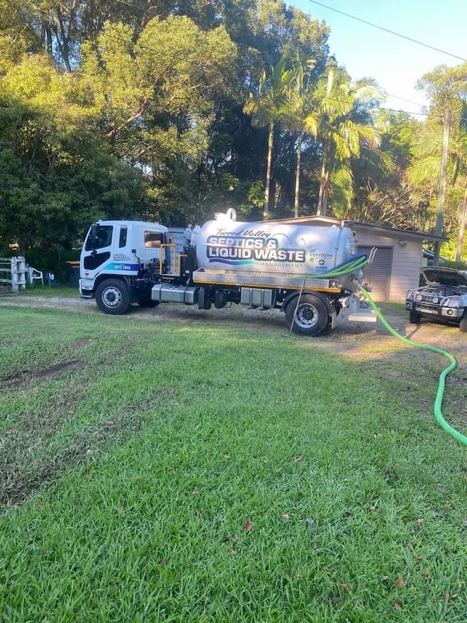 Large Truck is Parked in a Grassy Field — Tweed Valley Septics & Liquid Waste Management in South Murwillumbah, NSW