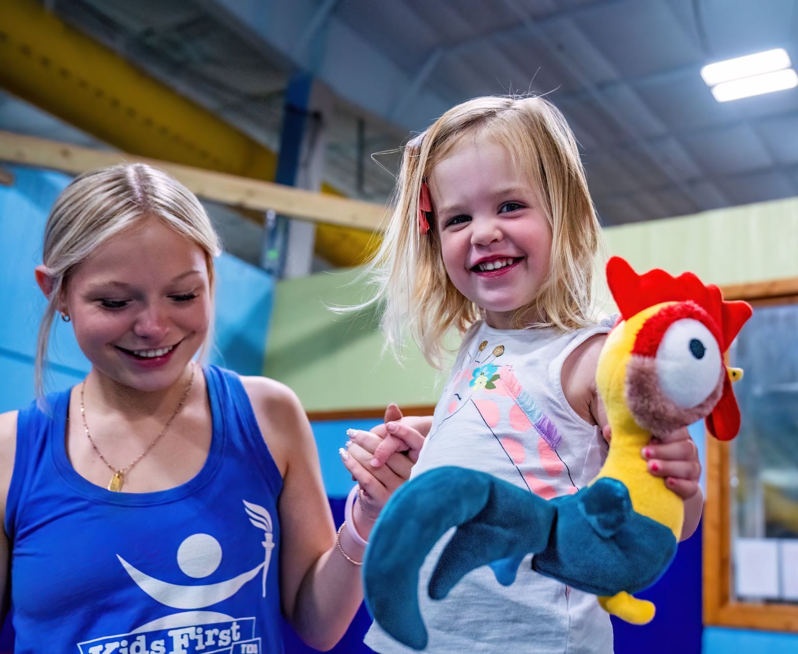 Teacher with gymnastics student at Kid First Too Tumble Bees