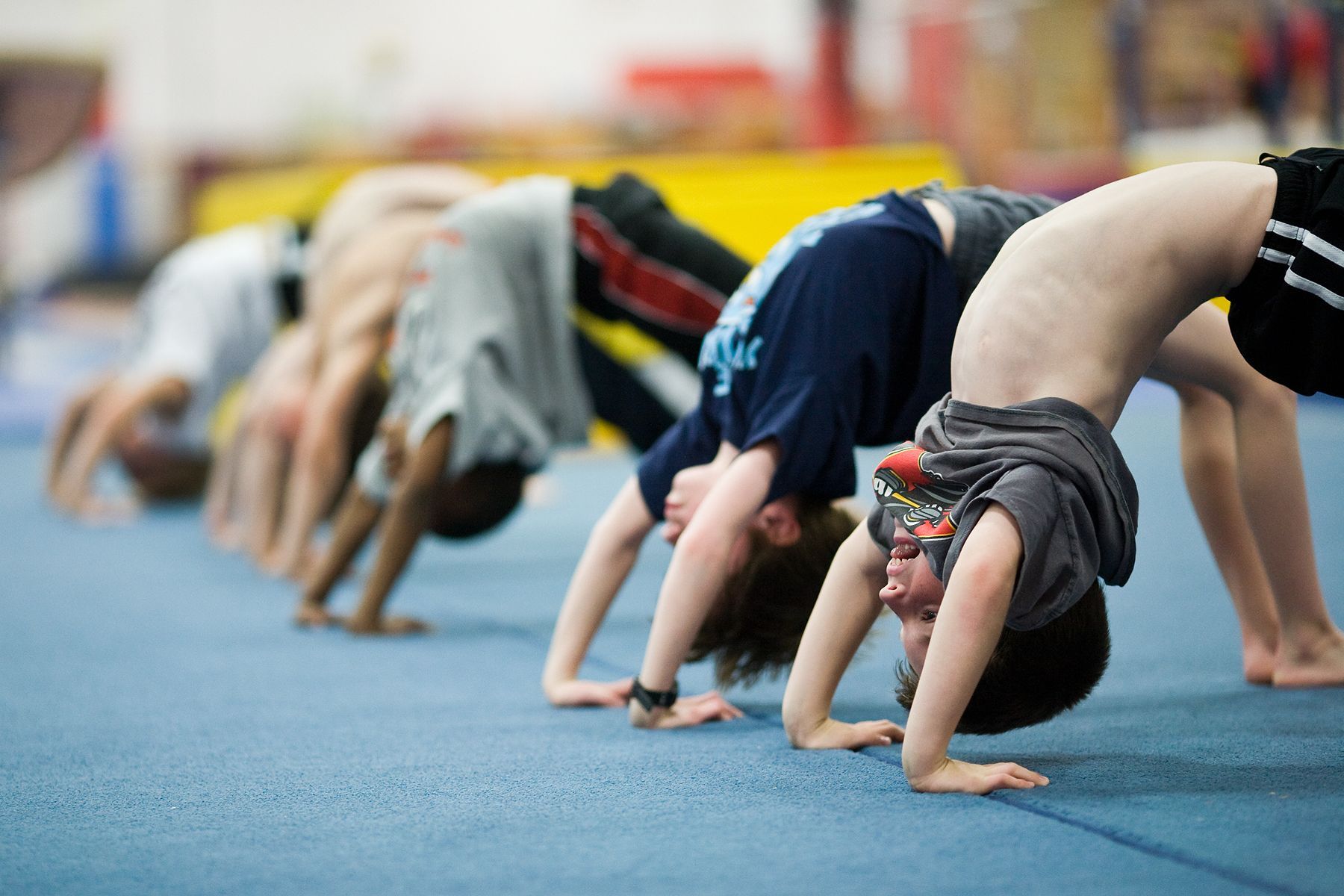 A group of young boys are doing bridges on the floor