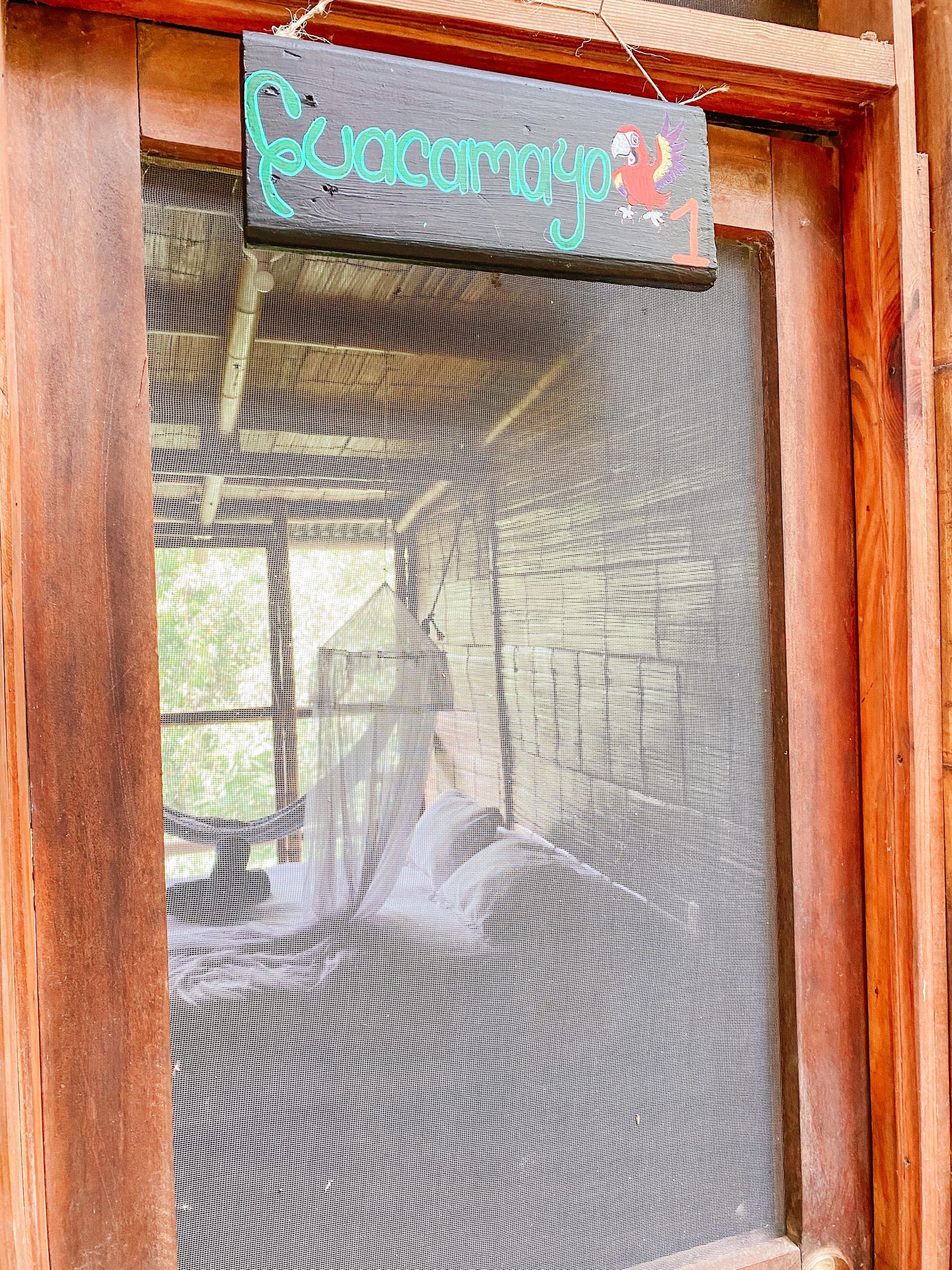 A wooden door with a sign hanging from it.