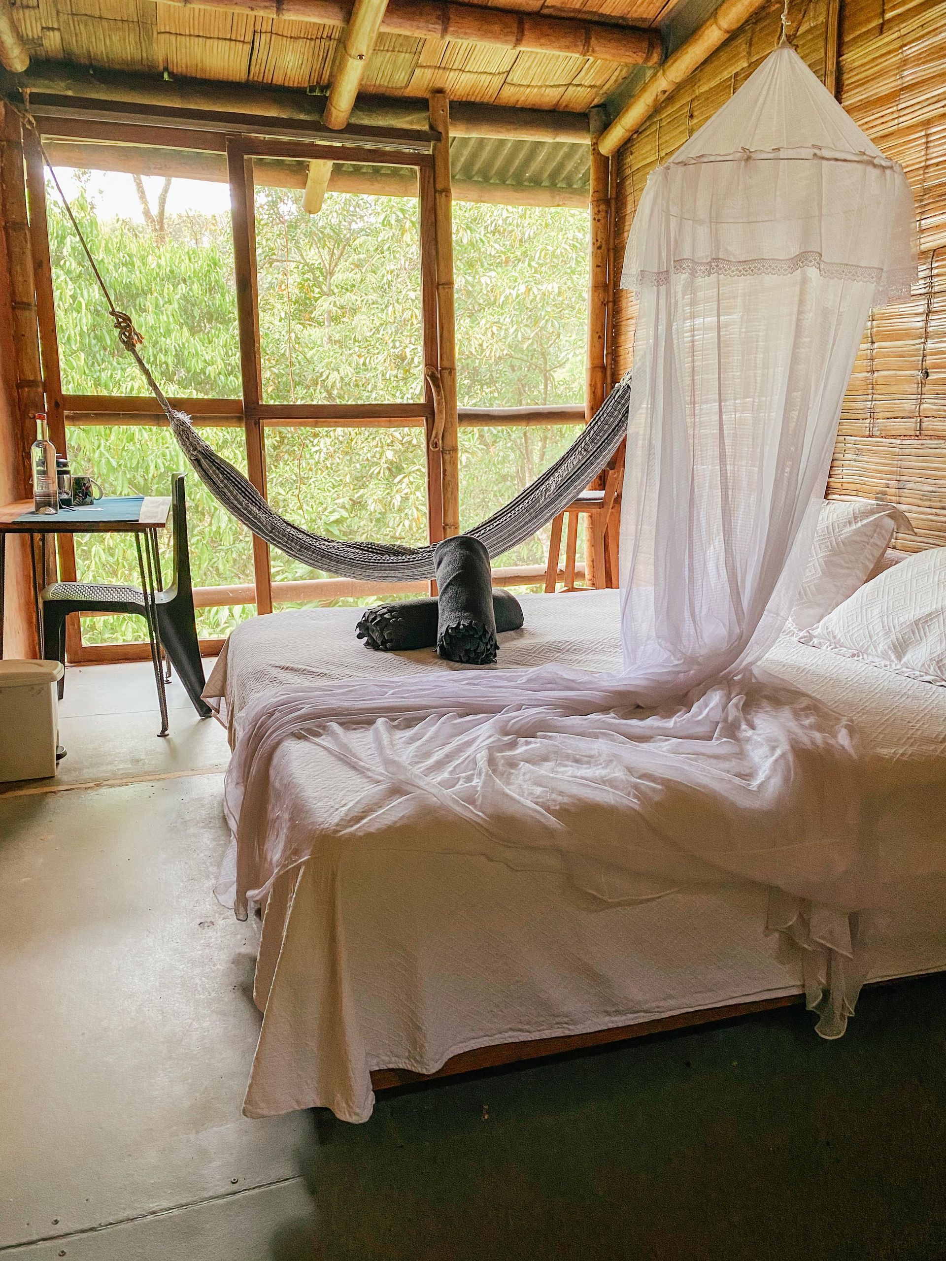 A bed with a hammock hanging over it in a room.