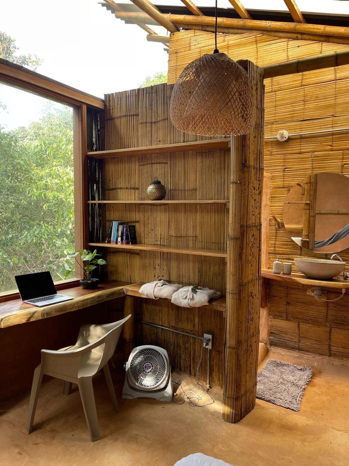 There is a desk with a laptop on it in the room.