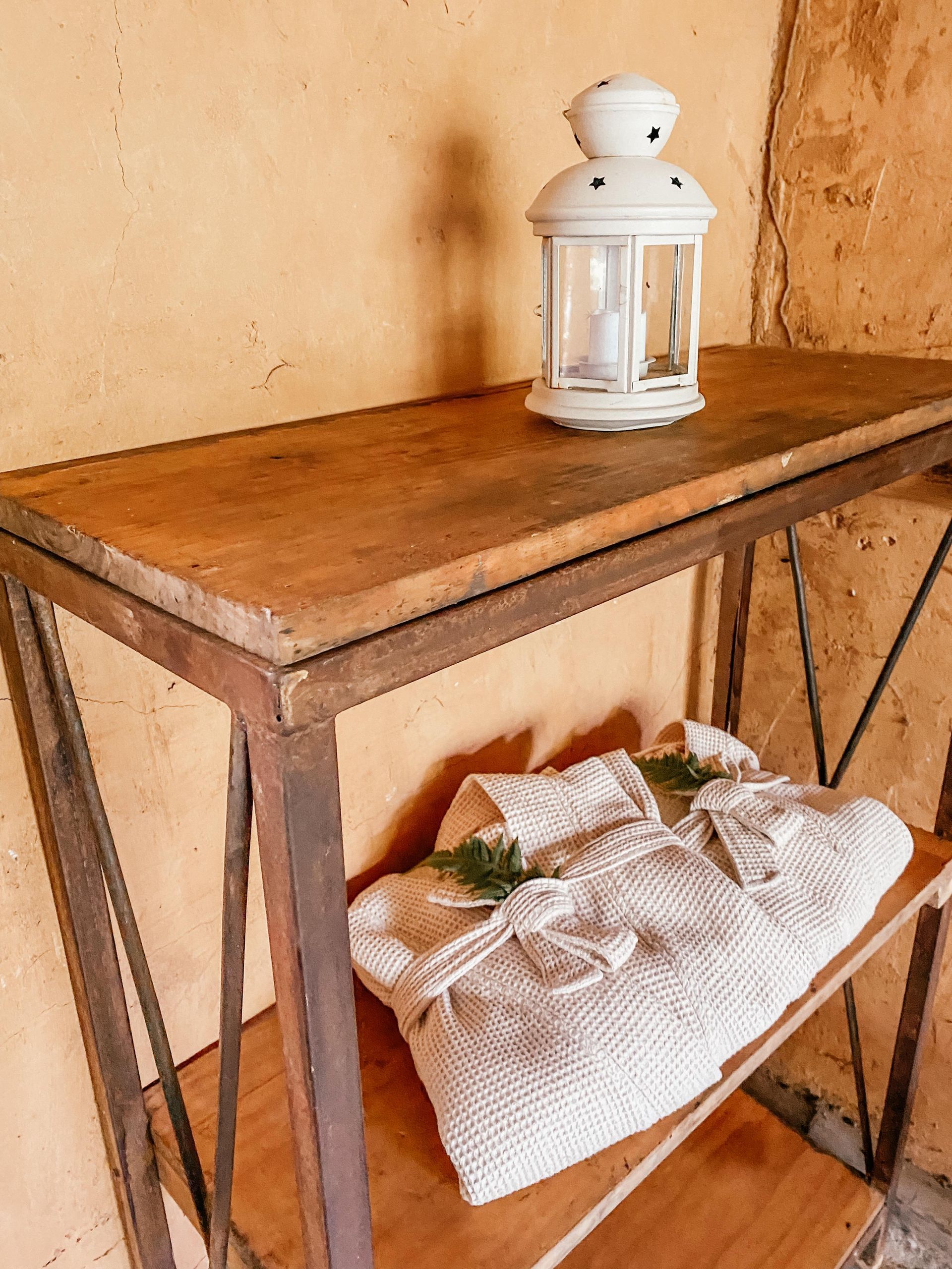 A wooden table with a white lantern on top of it