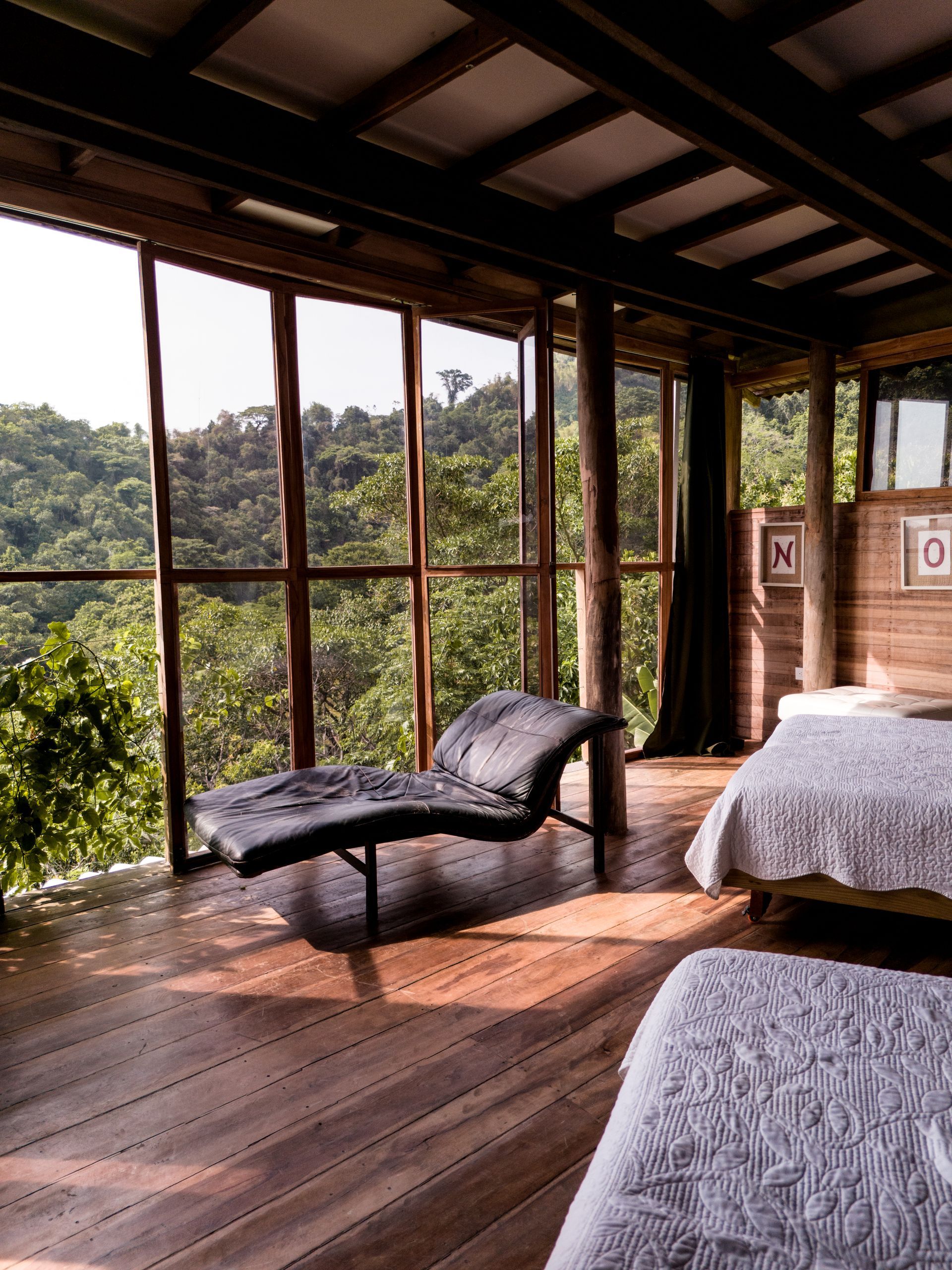 A bedroom with two beds and a chaise lounge