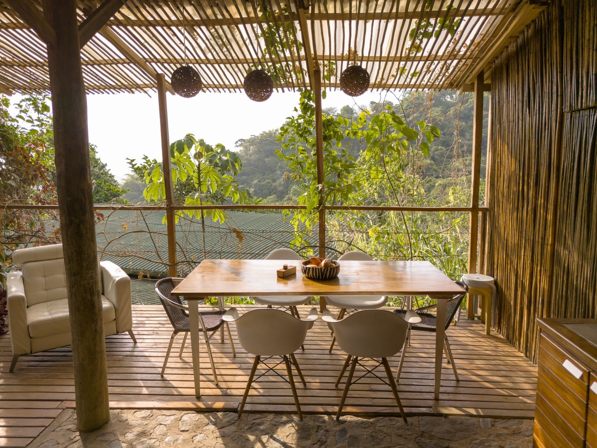 There is a table and chairs on the deck with a view of the trees.
