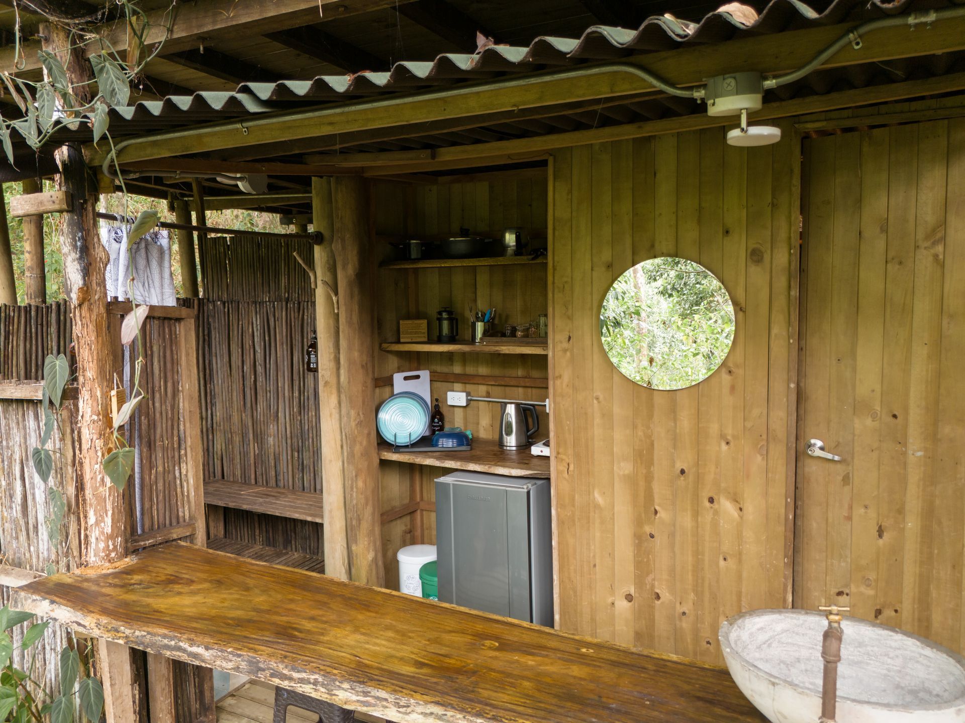A wooden building with a sink and a refrigerator