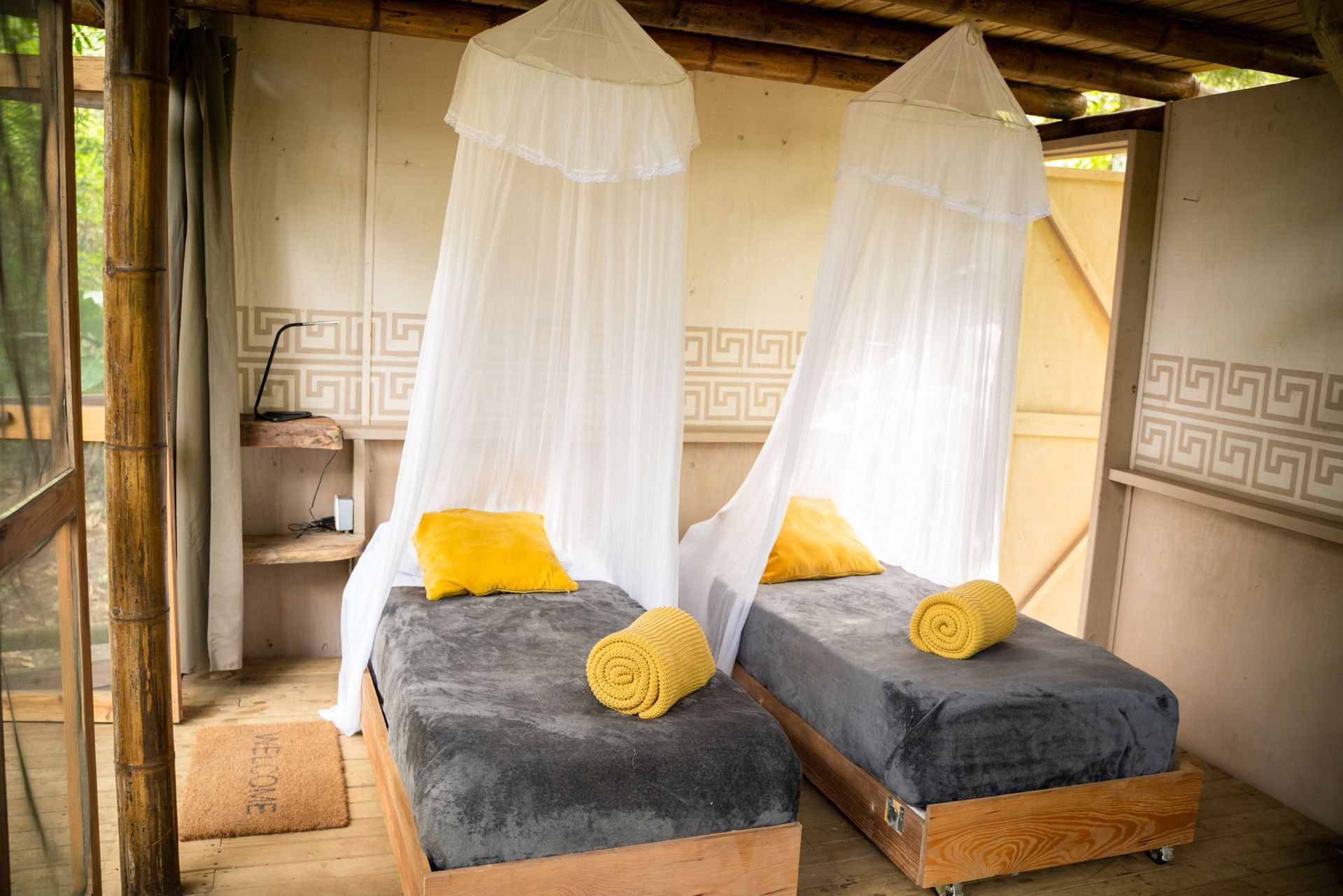 There are two beds in the room with canopies over them.