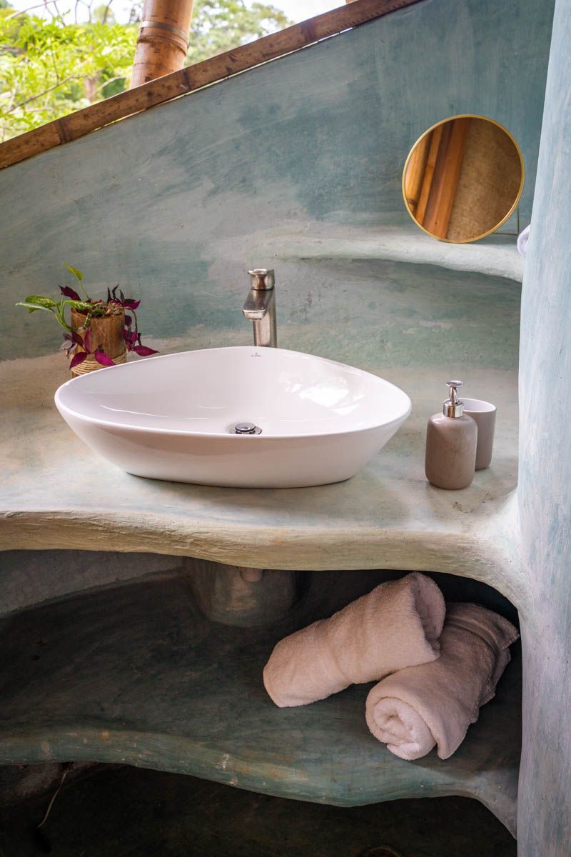 A bathroom with a sink , mirror and towels on the counter.