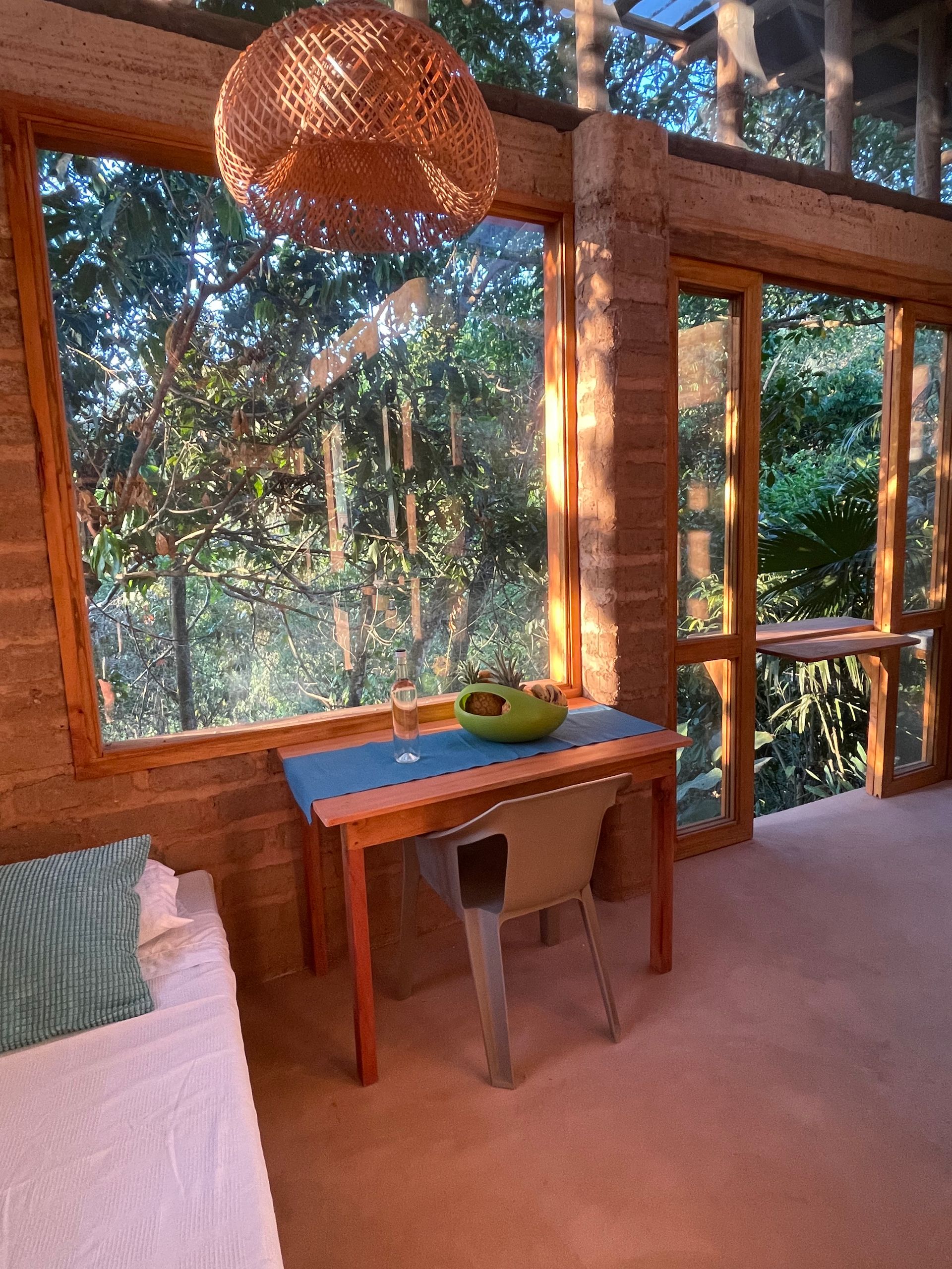 A room with a table and chairs in front of a window.