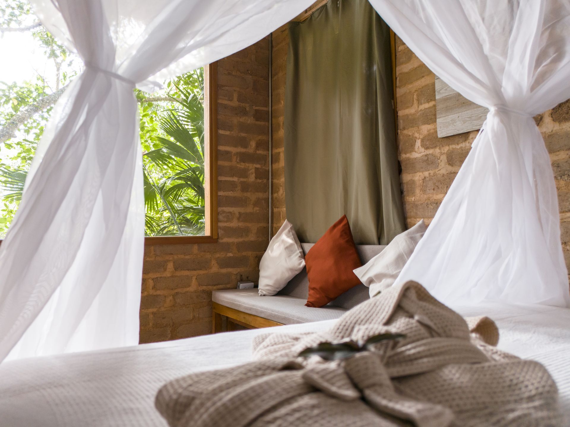 A bedroom with a canopy bed and a window