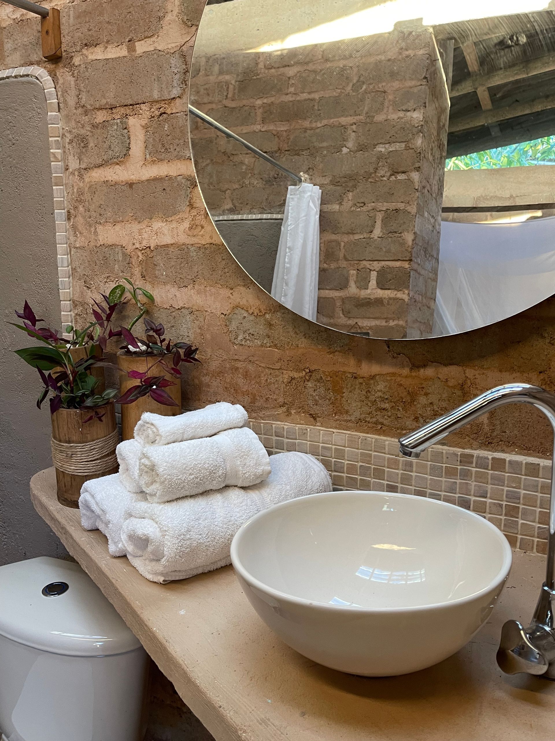 A bathroom with a sink , toilet and mirror.